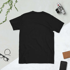 Back view of black Olympic Games Paris 2024 short-sleeve unisex t-shirt lying flat, surrounded by lifestyle accessories.