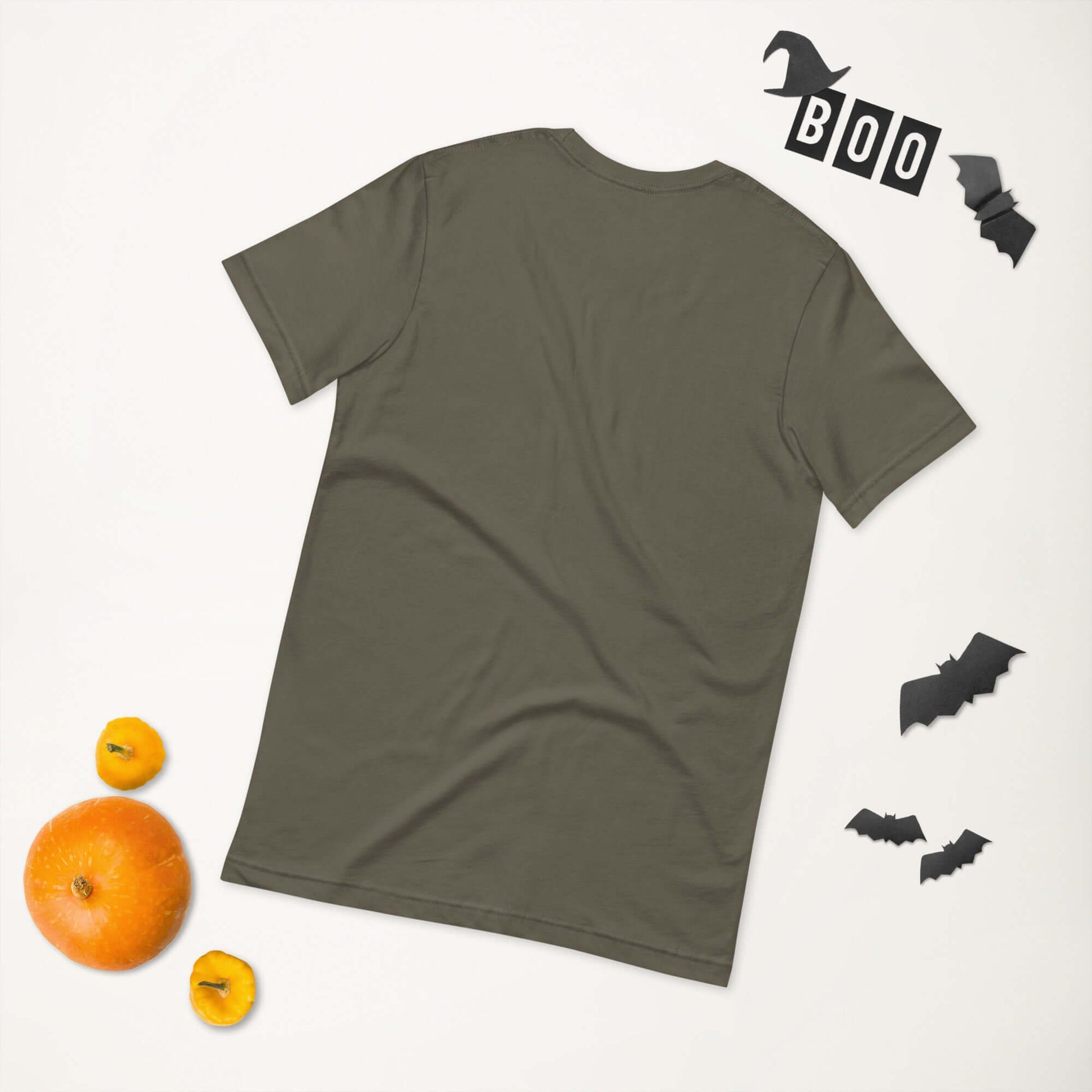 Unisex olive green t-shirt back view with Halloween-themed decorations, including mini pumpkins, bats, and "BOO" sign.