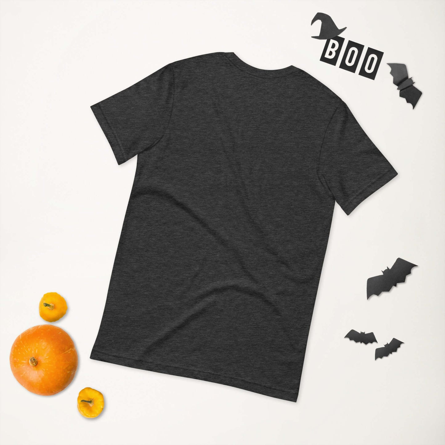 Black unisex t-shirt displayed with Halloween decorations, including "Boo" sign, bats, and pumpkins.